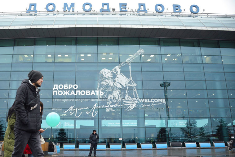 Люди идут вдоль терминала аэропорта Домодедово
