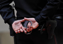 полицейский держит наручники