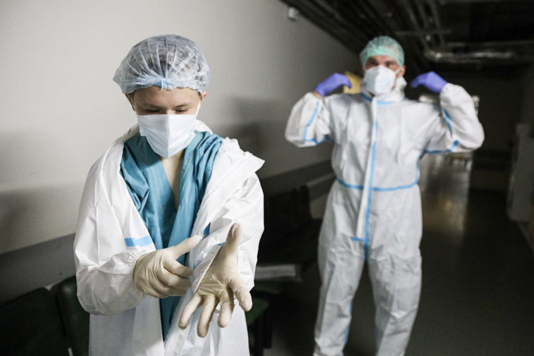 Сотрудники больницы надевают защитные костбмы в условиях эпидемии коронавиурса