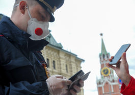Житель Москвы предъявляет пропуск полицейскому во время режима самоизоляции в Москве