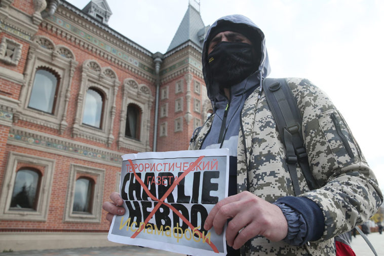 Мужчина с плакатом с надписью «Charlie Hebdo – терористический газета» у здания посольства Франции в Москве