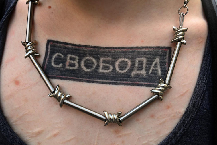 Татуировка «свобода» и ожерелье в виде колючей проволоки
