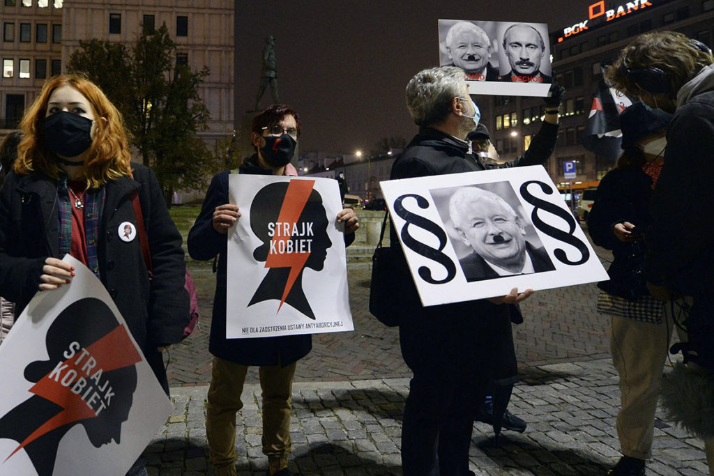Протестующие держат таблички с надписью "женская забастовка" в Варшаве во время протестов против запрета абортов