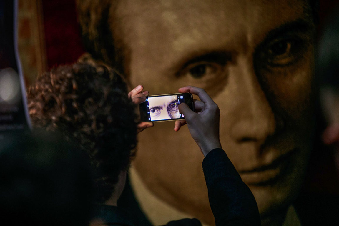 Человек фотографирует портрет Владимира Путина