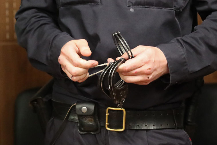 Полицейский держит наручники