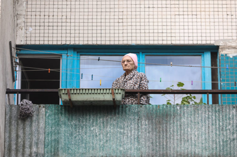 Женщина на балконе в период самоизоляции