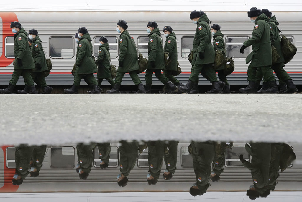 Солдаты идут на вокзале вдоль вагона
