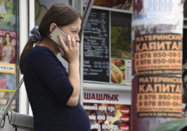 Беременная женщина говорит по мобильному телефону.