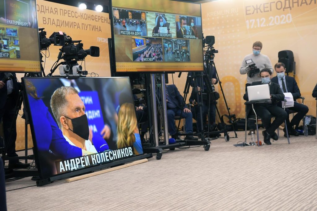 Специальный корреспондент ИД "Коммерсантъ" Андрей Колесников (на экране) во время пресс-конференции Владимира Путина