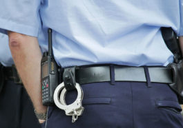Полицейский с оружием и наручниками