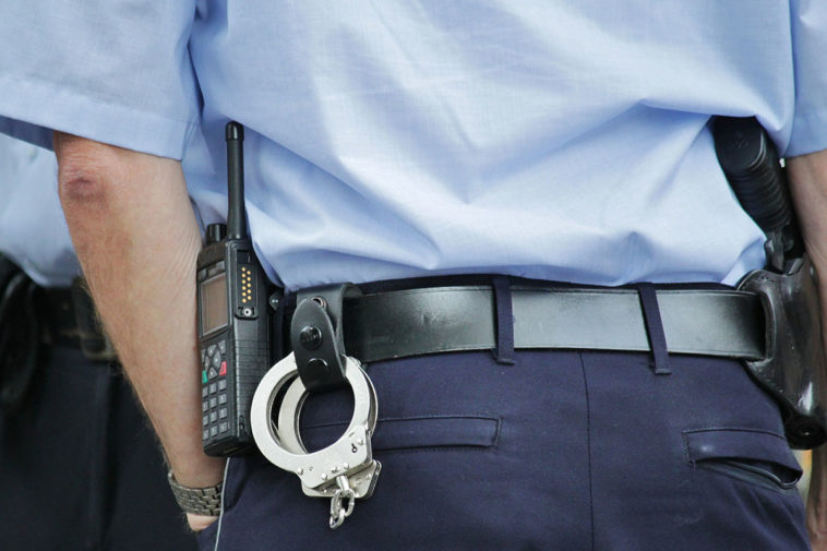 Полицейский с оружием и наручниками