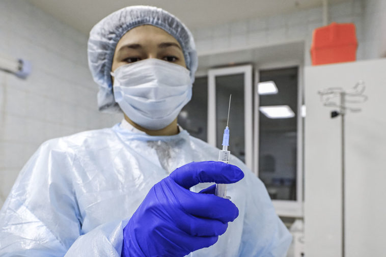 Медицинский работник перед вакцинацией добровольца от коронавирусной инфекции