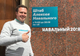 Николай Ляскин на фоне таблички штаб Навального
