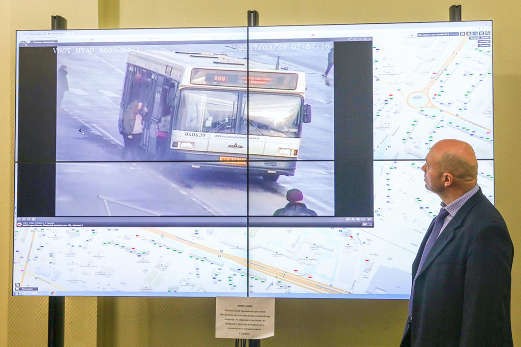 Мужчина наблюдает за перемещением автобуса по видеонаблюдению