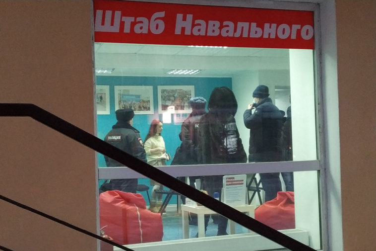 Полиция и сотрудники штаба Навального в окне штаба Навального в Омске