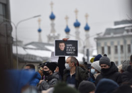 Участник митинга в Москве держит плакат