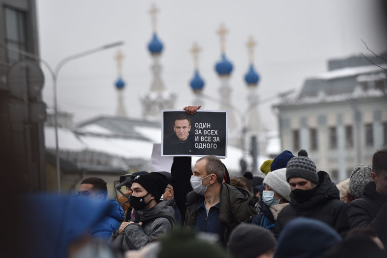 Участник митинга в Москве держит плакат