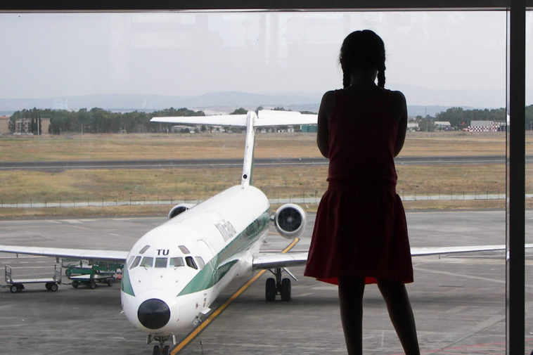 Женщина стоит перед самолетом