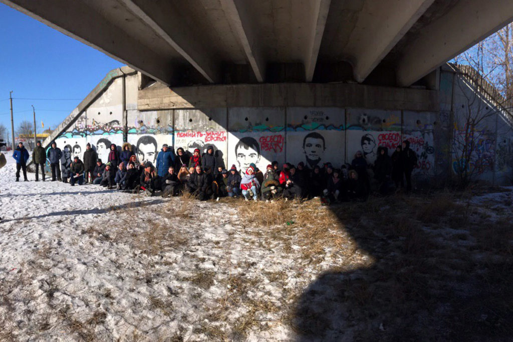 Активисты и родственники фигурантов дела «Сети» на фоне граффити с портретами ребят из «Сети» и Азата Мифтахова