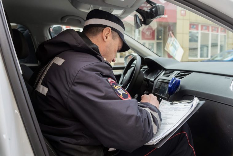 Сотрудник ДПС оформляем протокол о нарушении в салоне служебного автомобиля полиции