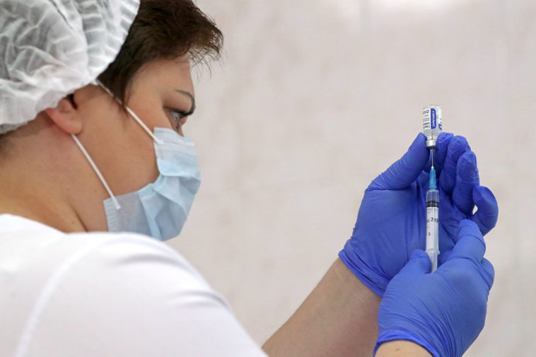 Вакцина "Гам-КОВИД-Вак" в руках медика во время вакцинации от коронавируса COVID-19