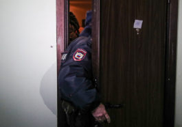 Сотрудник полиции заходит в квартиру Алексея Навального