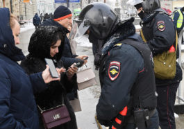 Сотрудники полиции проверяют телефоны прохожих во время протестной акции 31 января в Москве
