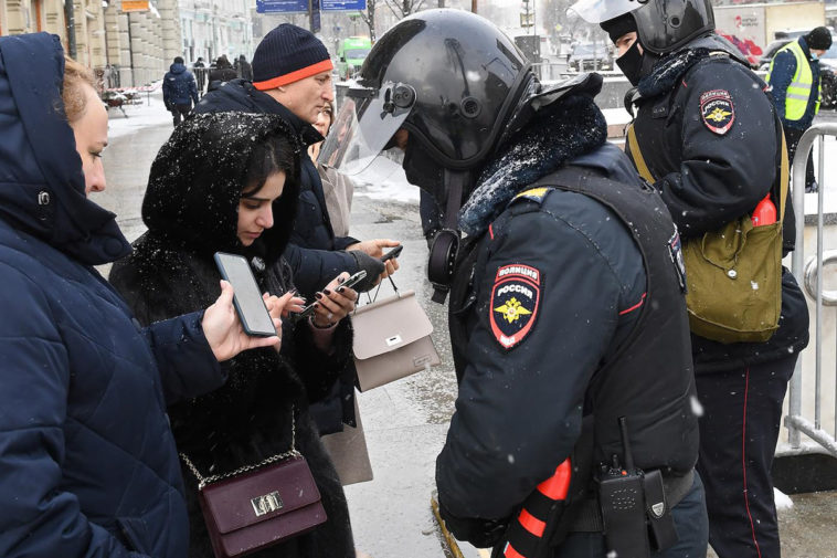 Сотрудники полиции проверяют телефоны прохожих во время протестной акции 31 января в Москве