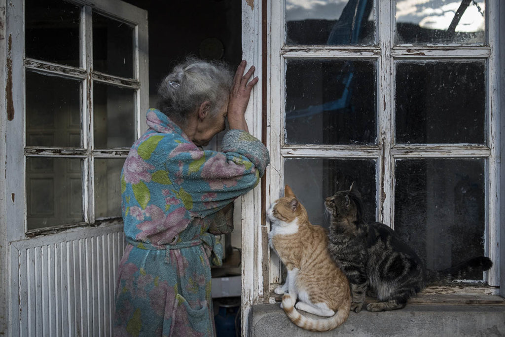 Абовян Асмик (69 лет) плачет у двери своего дома в селе Неркин Сус, Нагорный Карабах