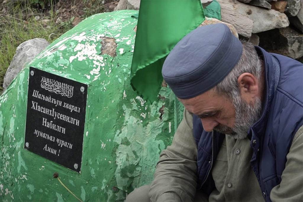 Муртазаали Гасангусейнов у камня с мемориальной табличкой, установленному на месте убийства его сыновей