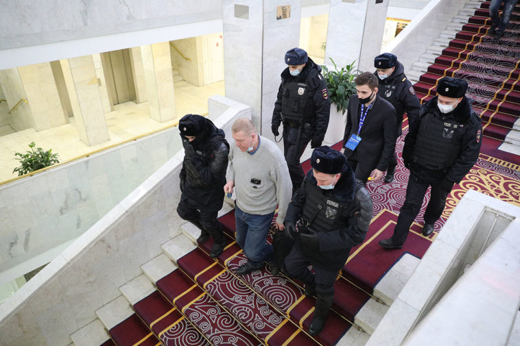 Полиция выводит участника первого форума независимых депутатов «Муниципальная Россия» в отеле «Измайлово Гамма-Дельта»