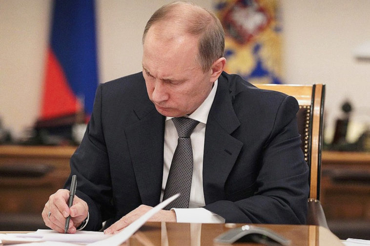 Владимир Путин подписывает документ