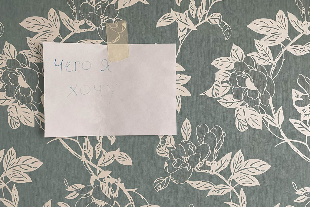 Лист на стене с надписью маркером «Чего я хочу» в квартире Нины