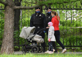Женщина с детской коляской перед полицией