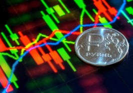 Монета со знаком рубля и биржевые графики