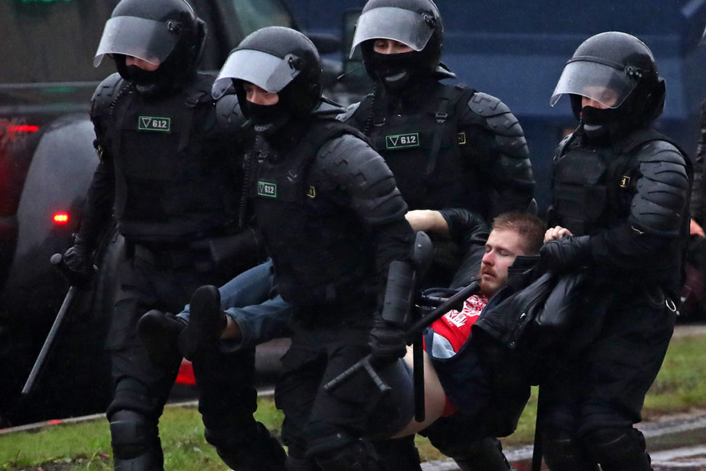 Сотрудники правоохранительных органов задерживают участника митинга в Минске после президентских выборов в Беларуси.