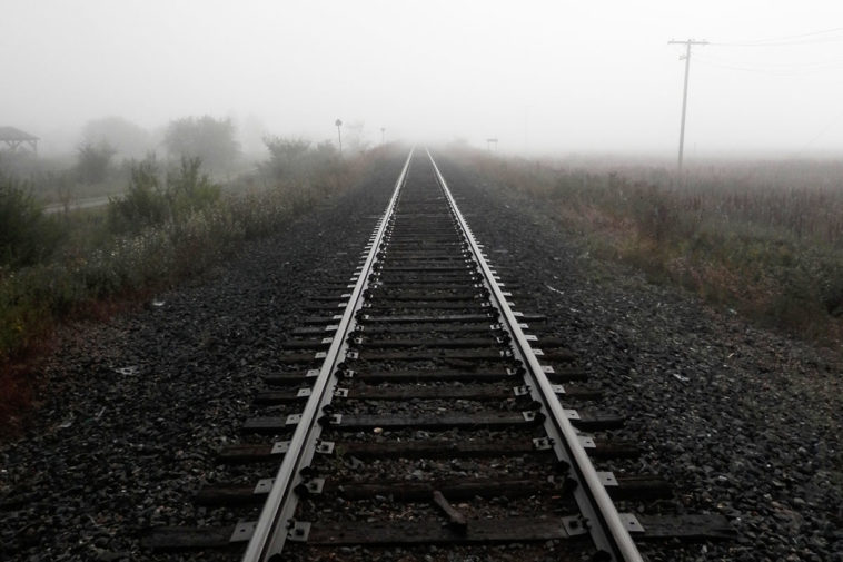 Железнодорожные рельсы уходят в туман