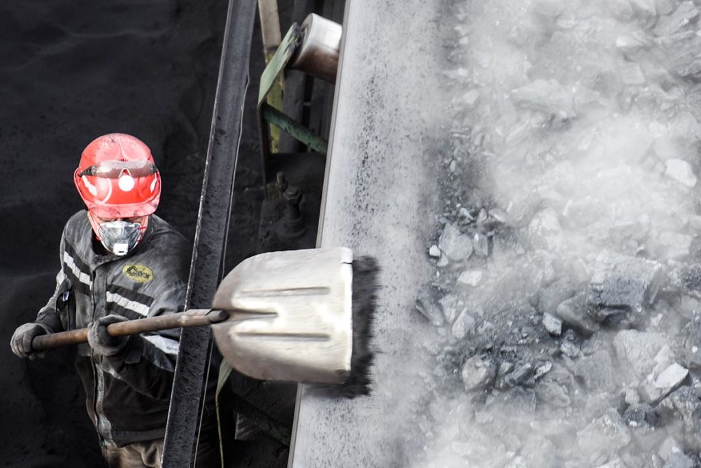 Рабочий во время погрузки угля на угледобывающем предприятии "Восточно-Бейский разрез" в Хакасии